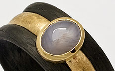Ring aus Carbon und Gelbgold mit grauem Sternsaphir